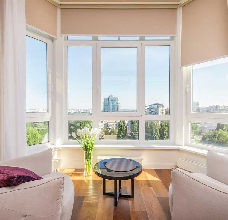 Bright sitting room showcasing roller shades and drapery